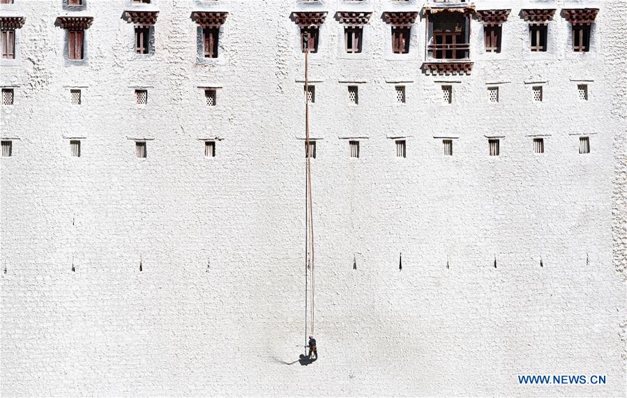 Workers paint wall of Potala Palace during annual renovation in Tibet