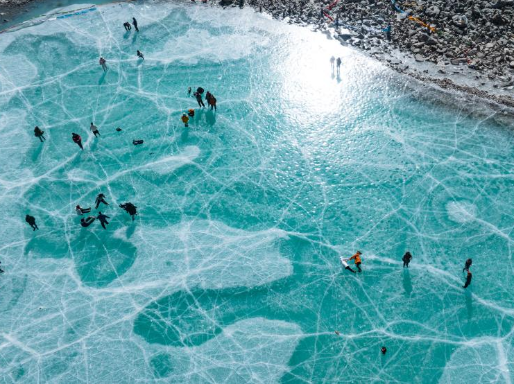 Tourists have fun on icy lake in Lhasa, China's Xizang