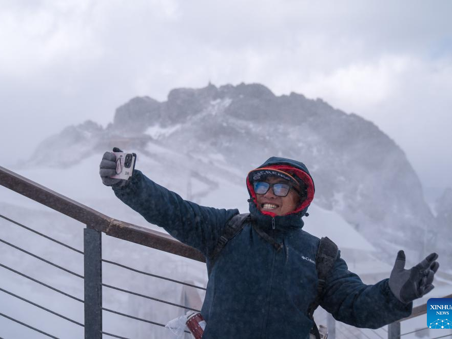 Picturesque snowy scene on snow mountain attracts tourists in SW China